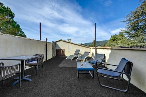 a group of chairs and tables on a patio at Hotel Bastide & SPA - Villa de Lourmarin in Lourmarin