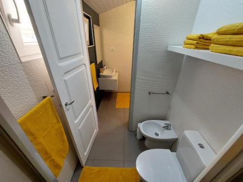een badkamer met een wit toilet en een gele handdoek bij Casa Rio Zêzere in Pedrógão Pequeno