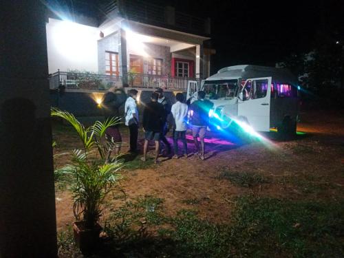 a group of people standing in front of a bus at night at Chikmagalur cool stay in Chikmagalūr