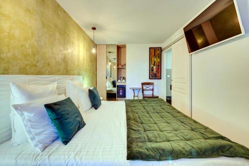 a bedroom with a large white bed with blue pillows at Hotel Bastide & SPA - Villa de Lourmarin in Lourmarin