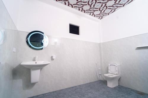 a white bathroom with a sink and a toilet at Passi Nature Villas Pasikuda in Kalkudah