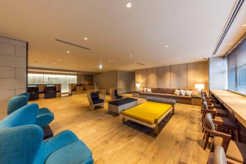 sala de estar con sillas azules y mesa amarilla en Via Inn Prime Sapporo Odori, en Sapporo