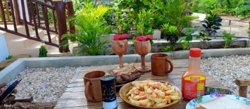 a wooden table with drinks and food on a patio at Villa de Flora Zanzibar 