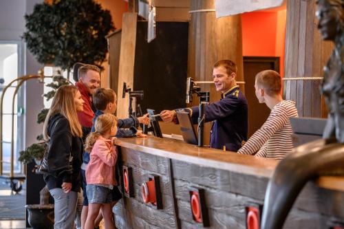 Un gruppo di persone si aggira intorno a un bar di Explorers Hotel Marne-la-Vallée a Magny-le-Hongre