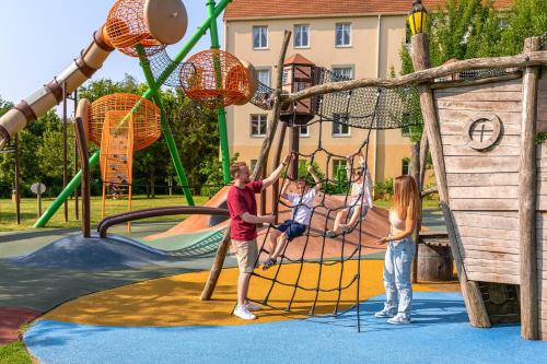 a man and a girl playing on a playground at Explorers Hotel Marne-la-Vallée in Magny-le-Hongre