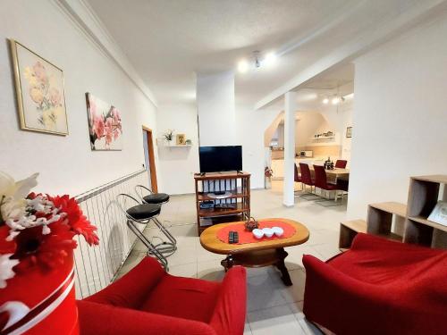 Apartman Jezerane في Jezerane: غرفة معيشة مع أرائك حمراء وتلفزيون