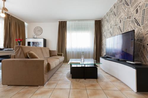 a living room with a couch and a flat screen tv at VILLA VITTORIA in Luxembourg