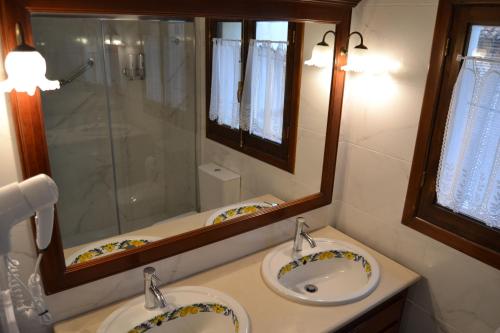 a bathroom with two sinks and a shower at tuGuest Palacio de la Madraza in Granada