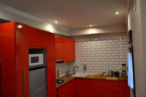 a kitchen with red cabinets and a white microwave at tuGuest Palacio de la Madraza in Granada
