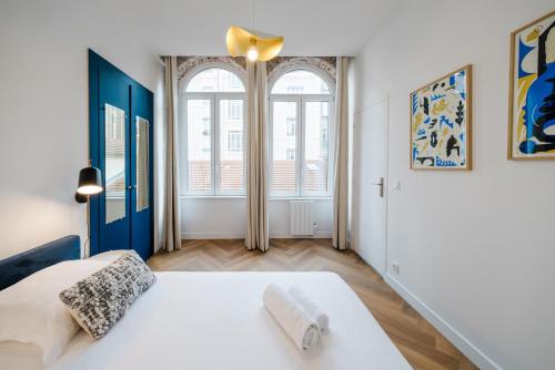- une chambre avec un lit blanc et 2 fenêtres dans l'établissement Lumineux T2, climatisé en centre ville AIL, à Lyon