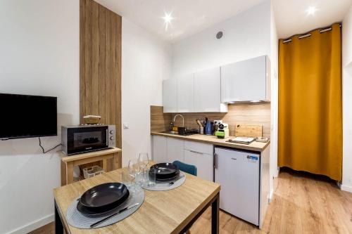 - une cuisine avec une table et deux verres dans l'établissement The Studio in the 2nd arrondissement AIL, à Lyon