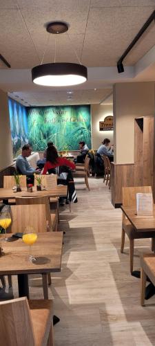 a restaurant with wooden tables and a large wall at Apartmenthaus Nr 1 in Lienz