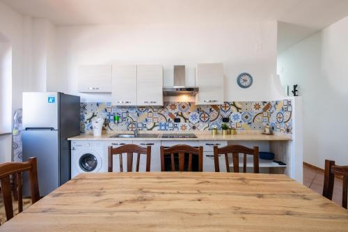 a kitchen with a table and chairs and a refrigerator at Villa Gaudì - Sagrada in Sant'Isidoro