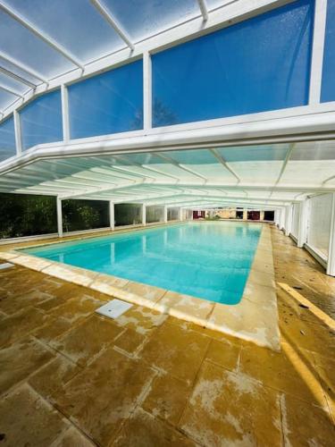 une piscine vide dans un grand bâtiment dans l'établissement Maison Les Palmiers* Piscine* Sarlat, à Sarlat-la-Canéda