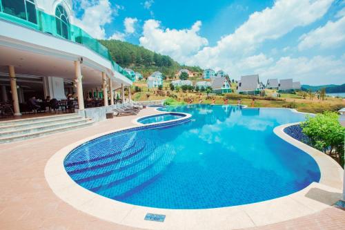 een groot zwembad naast een gebouw bij Dalat Wonder Resort in Da Lat
