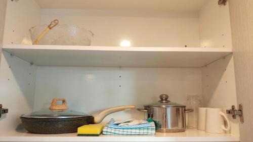 a kitchen shelf with a tea pot and other kitchen items at Sky Stars Essential Home in Auckland