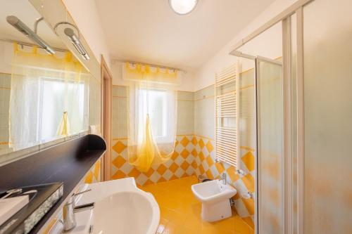y baño con aseo, lavabo y ducha. en Villa Soave, en Citta' Sant'Angelo