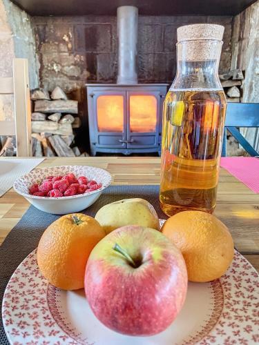 a plate of apples and oranges and a bottle of syrup at LA FERME DE NEHOU in Gatteville-le-Phare