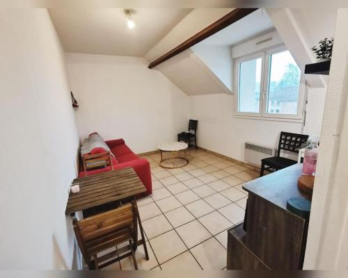 ein Wohnzimmer mit einem roten Sofa und Stühlen in der Unterkunft Le cozy in Sartrouville