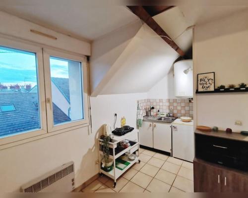 eine kleine Küche mit einem großen Fenster und einer Theke in der Unterkunft Le cozy in Sartrouville