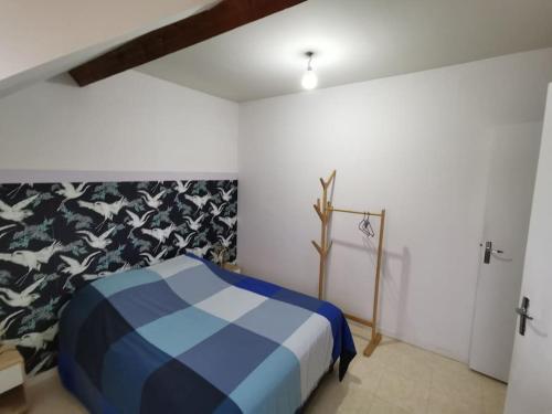 ein Schlafzimmer mit einem blauen und weißen Bett in einem Zimmer in der Unterkunft Le cozy in Sartrouville