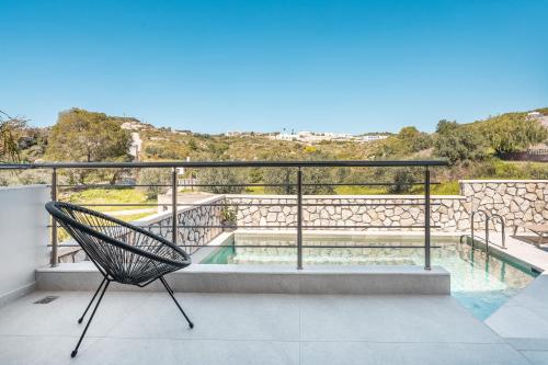 a chair on a balcony with a swimming pool at Eldorado Luxury Villa in Afantou