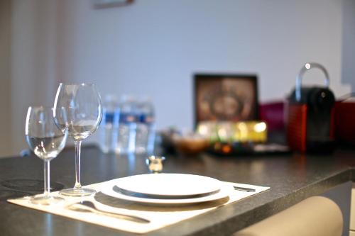 a table with a plate and two wine glasses at Royal Apartments Brussels in Brussels