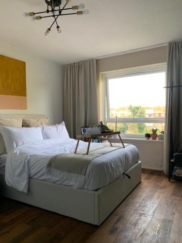 a bedroom with a bed and a large window at Light & Airy Oasis in South Norwood