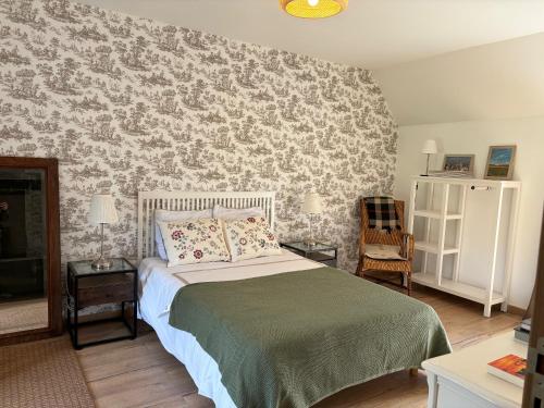 a bedroom with a bed with a floral wallpaper at LA FERME DE NEHOU in Gatteville-le-Phare