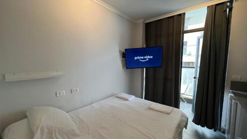 a bedroom with a bed and a tv on the wall at Gabriel Apartments - JAFFA Street 214 Suits + Balcony in Bet HaKerem