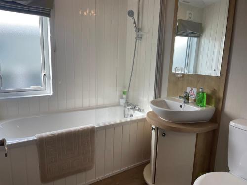 a bathroom with a sink and a tub and a toilet at 42 Woodland Walk Pevensey Bay Holiday Park sleeps 6 in Pevensey