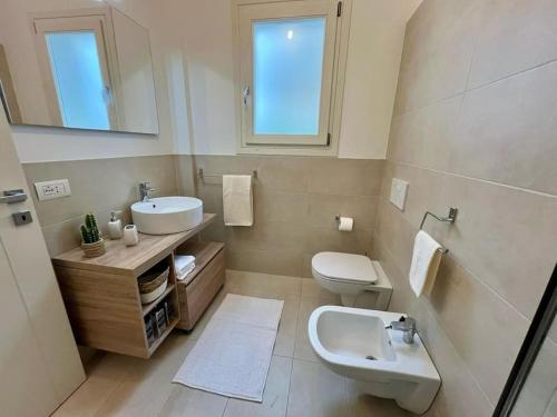 W łazience znajduje się umywalka, toaleta i lustro. w obiekcie Residenza Bramante w mieście Olbia
