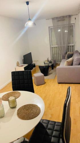 uma sala de estar com uma mesa e um sofá em Appartement t2 au chartrons em Bordéus