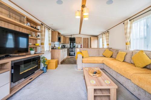 a living room with a couch and a tv at Your Ultimate Holiday Rental at Pevensey Bay 35 Woodland Walk in Pevensey