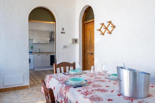 a dining room table with a red and white table cloth at Villa Gaudì - Milà in Sant'Isidoro