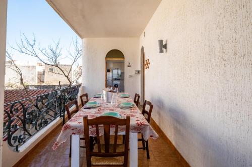 a dining room with a table and chairs on a balcony at Villa Gaudì - Milà in Sant'Isidoro
