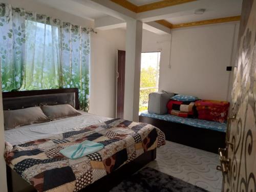 um quarto com uma cama e uma janela em Pradhan's Homestay em Takdāh