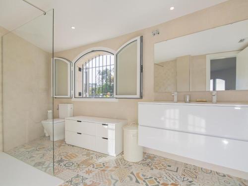 a bathroom with a sink and a toilet and a mirror at Villa Saramel con vistas panorámicas al mar in Sant Antoni de Calonge