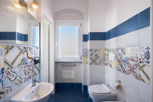 a bathroom with a sink and a toilet and a window at Villa Gaudì - Milà in Sant'Isidoro