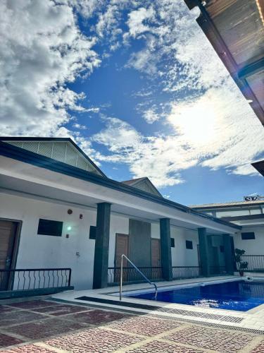 a house with a swimming pool and a cloudy sky at Bavarian Guest House in Angeles