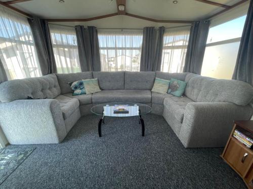 a living room with a couch and a table at 27 Tower View Pevensey Bay Holiday Park in Pevensey