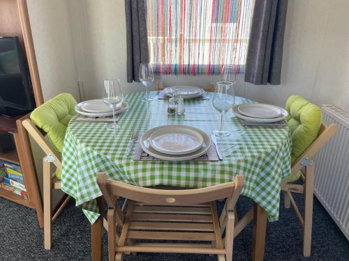 a table with a green and white checkered table cloth at 27 Tower View Pevensey Bay Holiday Park in Pevensey