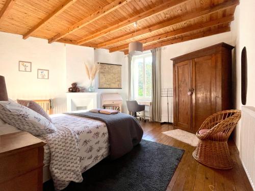 a bedroom with a bed and a chair in a room at Les Régniers - 2 gîtes pour partir ensemble in Eynesse