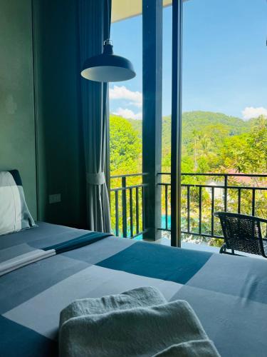 a bedroom with a bed and a balcony with a view at Evergreen Koh Chang Resort in Ko Chang
