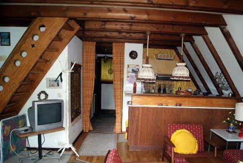 a living room with a tv and a kitchen at Ferienhaus Bergwiese in Siegsdorf