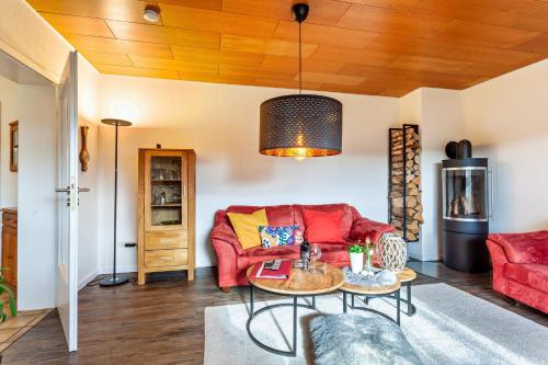 a living room with a red couch and a table at Haus Frigger in Olsberg