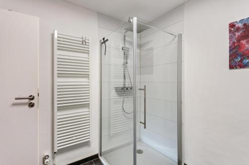 a glass shower stall in a white bathroom at Haus Frigger in Olsberg