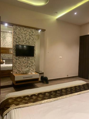 a bedroom with a tv on the wall and a bed at Hotel New BMS pride in Amritsar