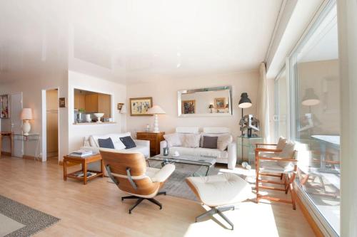 un salon avec un canapé et des chaises dans l'établissement Face mer : Les Vagues Bauloises, à La Baule