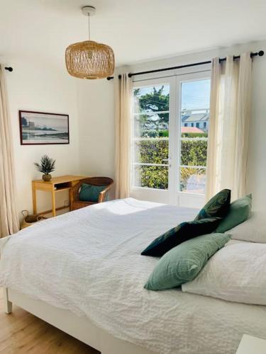 une chambre avec un grand lit avec une fenêtre dans l'établissement Villa Les coquelicots La Baule, à La Baule